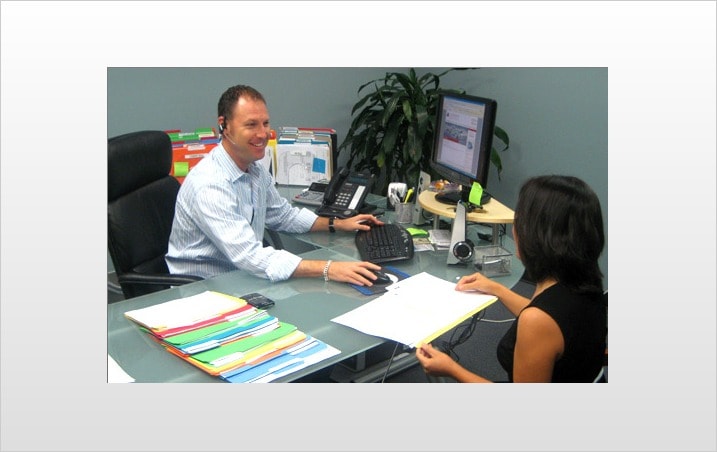 Oren Weintraub, president of Authority Car Buying Specialists, reviews a contract with a client before she signs.